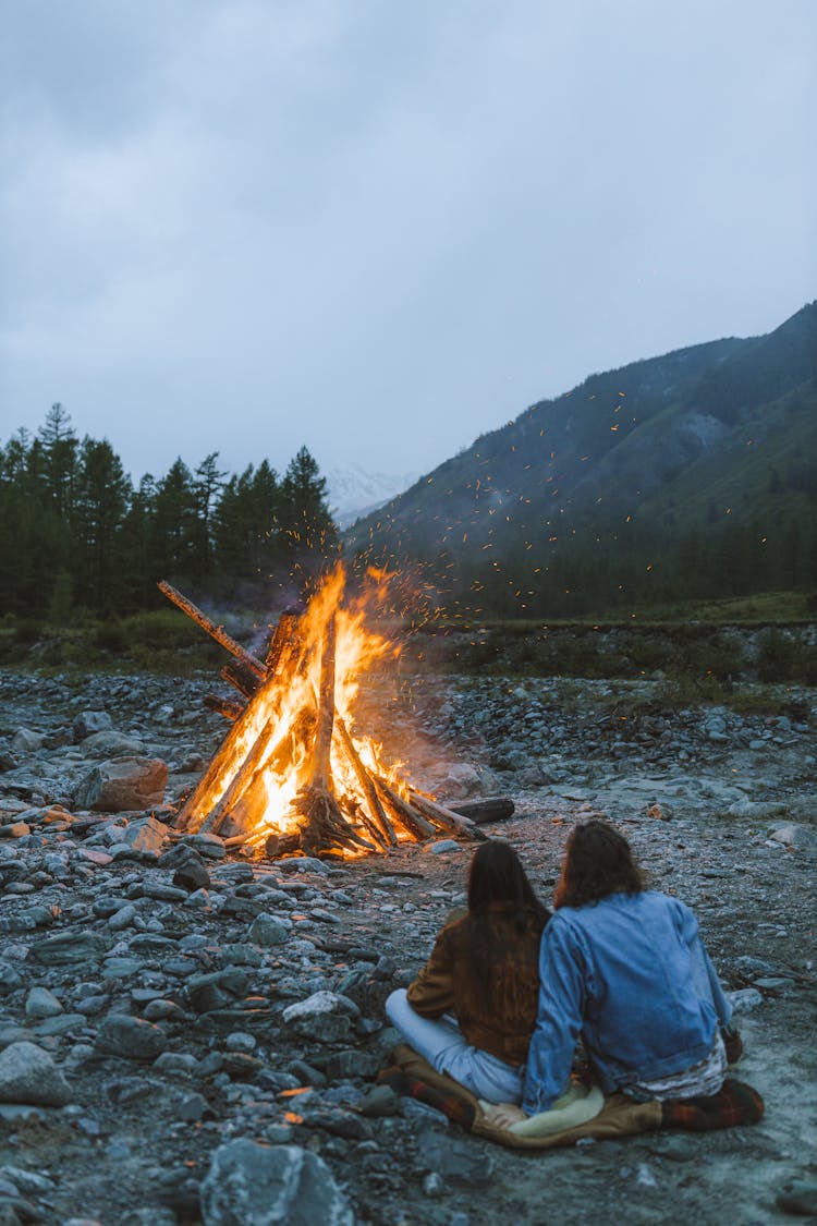 Couple Sitting Near A Bonfire