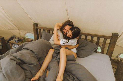 Free Happy couple embracing in a cozy tent, conveying love and togetherness. Stock Photo