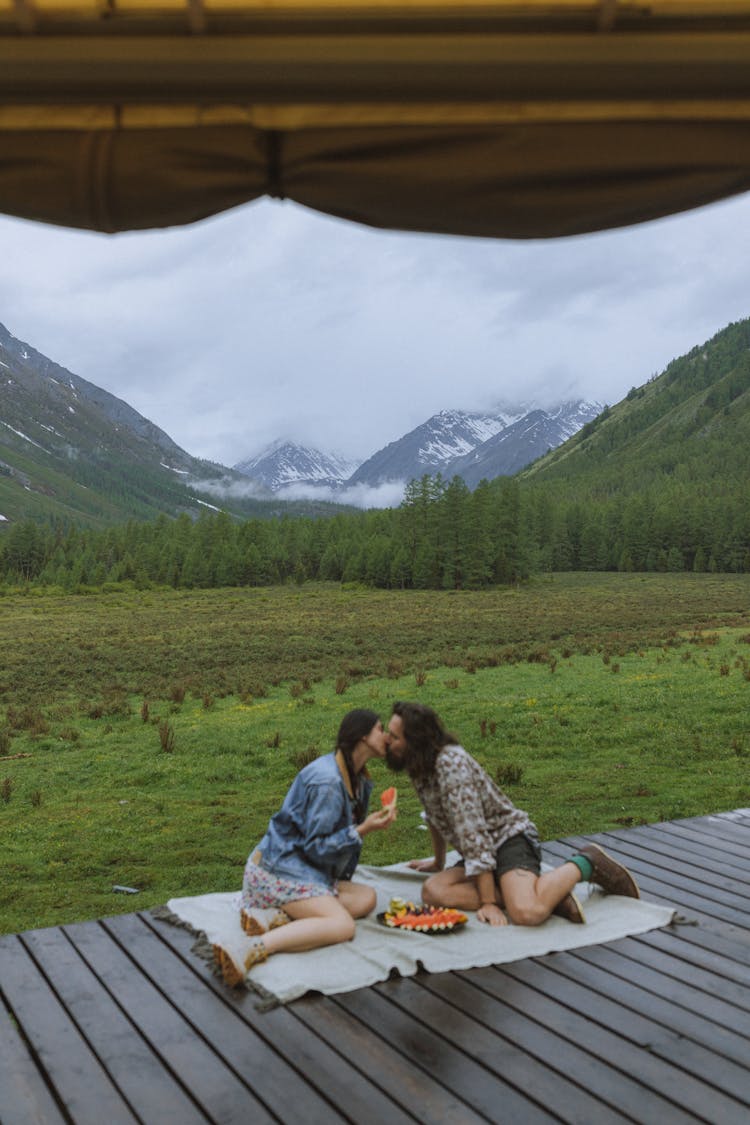 A Man And Woman Kissing At Each Other 