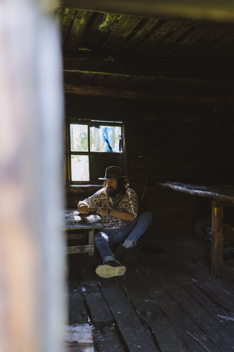 A Man Sitting At The Wooden Floor