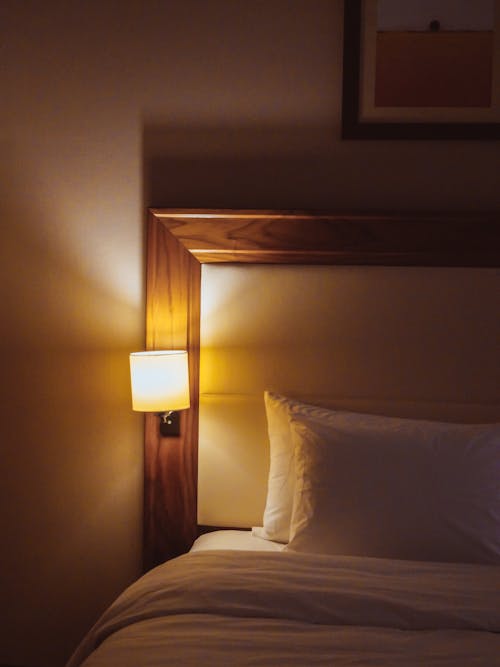 Free Wooden Framed Bed with Lamp on Headboard Stock Photo