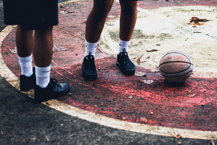 Players on a weathered outdoor court — photo by Christopher Ugale on Pexels
