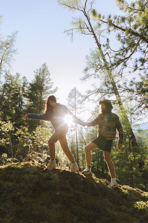 Man and Woman Standing on Green Grass in the Forest