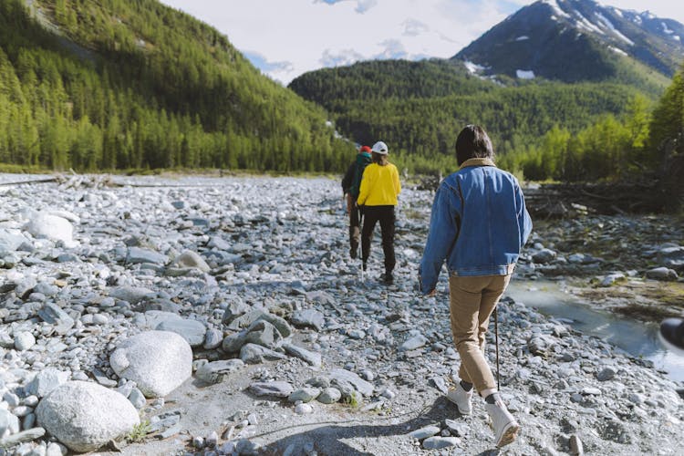 Group Of People Walking On Riverbanks