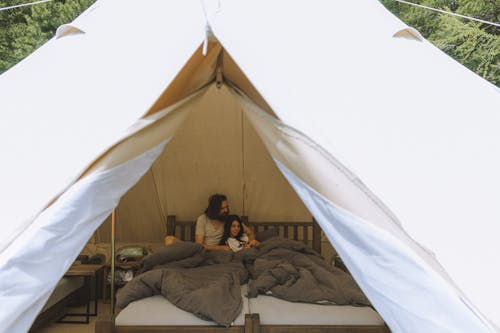 Free A Couple Sitting on the Bed Inside the Tent Stock Photo