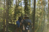 Man in Blue Jacket Wearing Brown Hat Standing in Forest