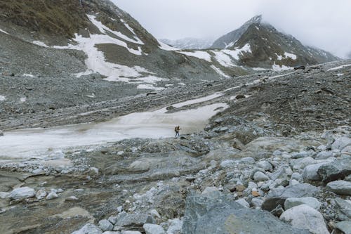 Person Hiking on a Rocky Mountain Area