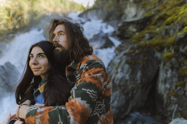 A Man Hugging A Woman Outdoors