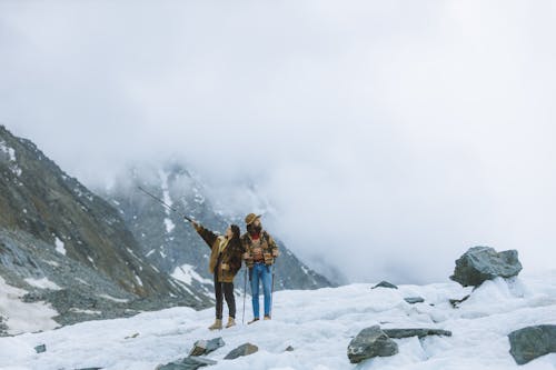 A Couple Hiking the Snow Covered Mountain