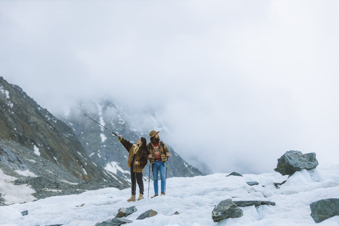 A Couple Hiking the Snow Covered Mountain