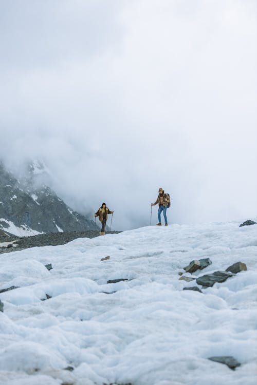 A Couple Hiking on Snow Covered Mountain