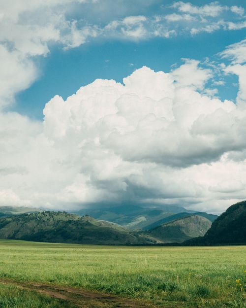 Free Expansive meadow with mountains under a cloudy sky in Katon-Karagay, Kazakhstan. Stock Photo