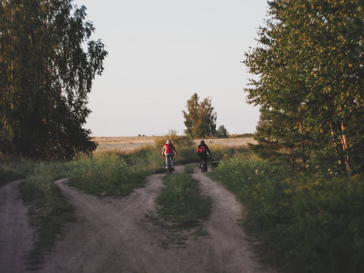 Man And Woman Biking On A Dirt Road