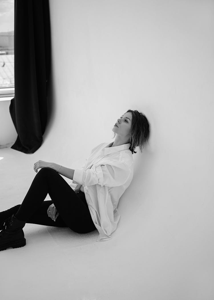 A Woman In A Button Down Shirt Sitting On The Floor