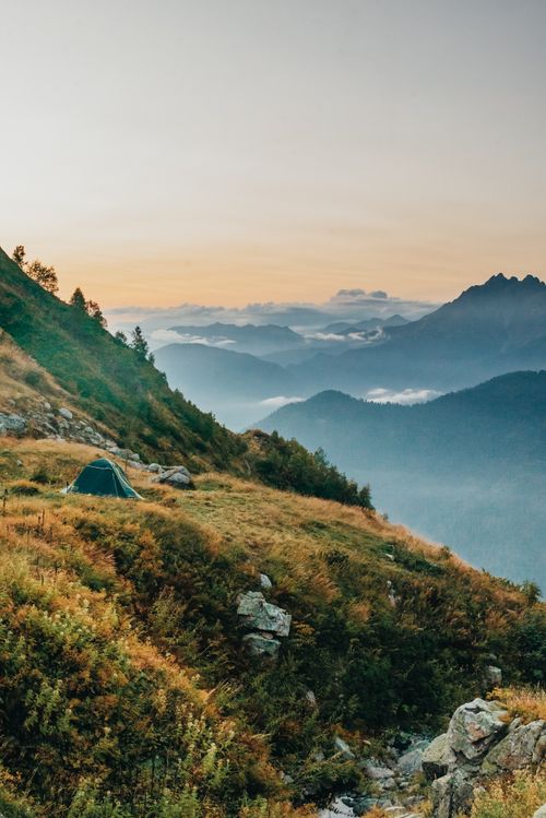 Free Tranquil camping scene in mountains with tent at sunrise. Stock Photo