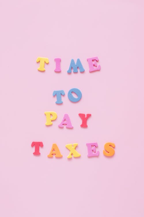 Colorful Letters on a Pink Background Creating a Sentence Time to Pay Taxes