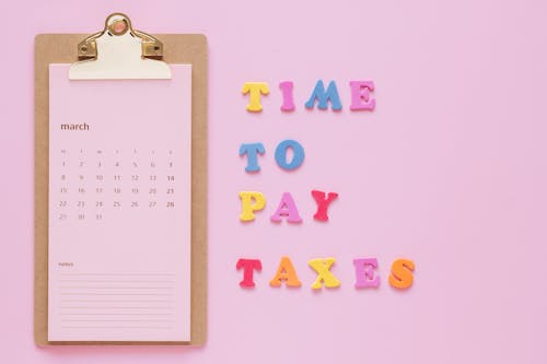 Time to Pay Taxes Sign by Clipboard Calendar 