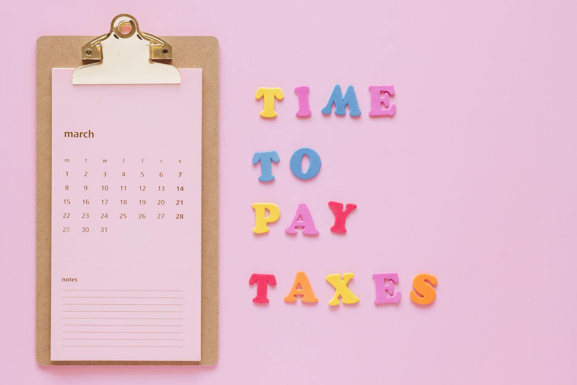 Time to Pay Taxes Sign by Clipboard Calendar