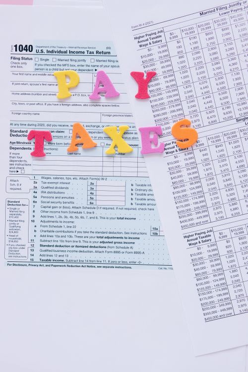 Free Colorful letters on tax forms, ideal for finance and tax-related themes. Stock Photo