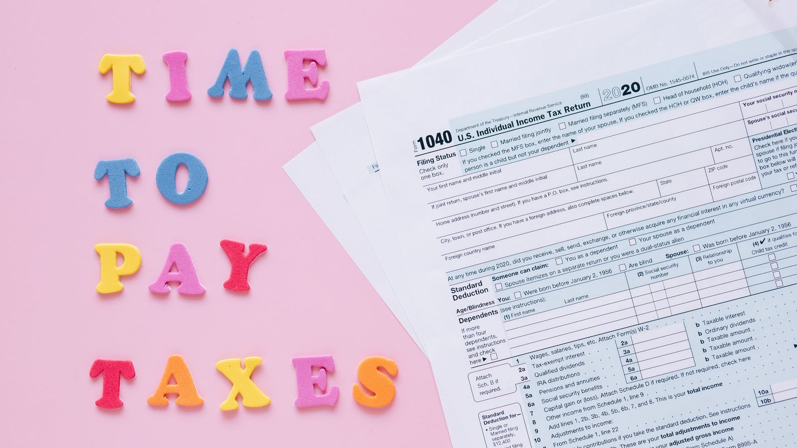 1040 tax forms with colorful 'Time to Pay Taxes' letters.