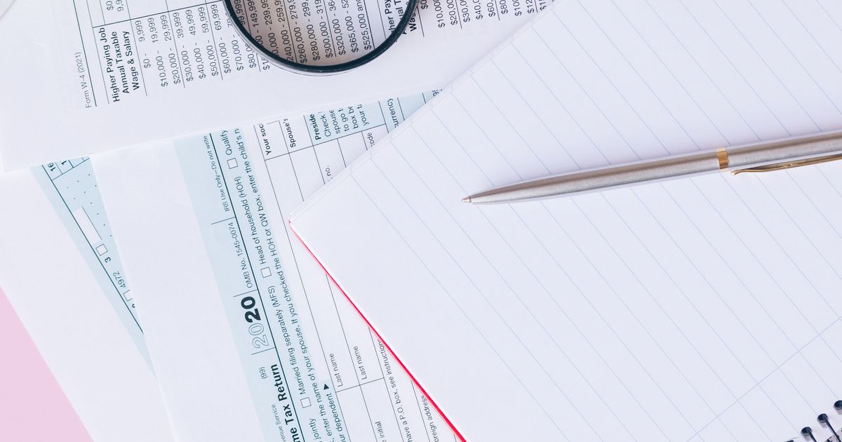 Formulaires d’impôt, loupe et stylo sur un bureau
