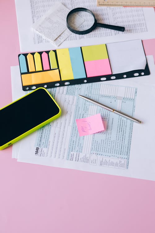 Cellphone and Sticky Notes on Top of Documents