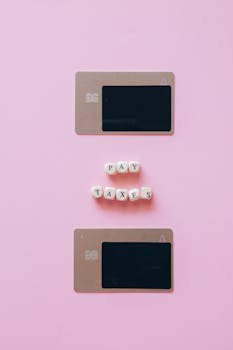 Artistic representation of tax payment using credit cards on a pink background.