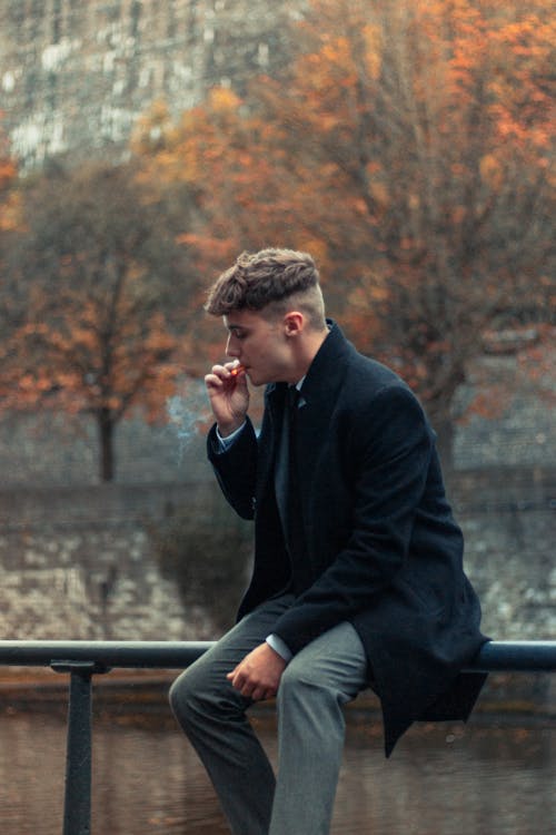 Free A Man in a Coat Smoking a Cigarette  Stock Photo