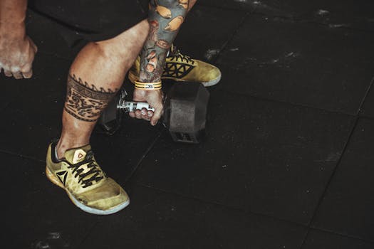 A tattooed individual lifting a dumbbell in a gym, showcasing fitness and style.