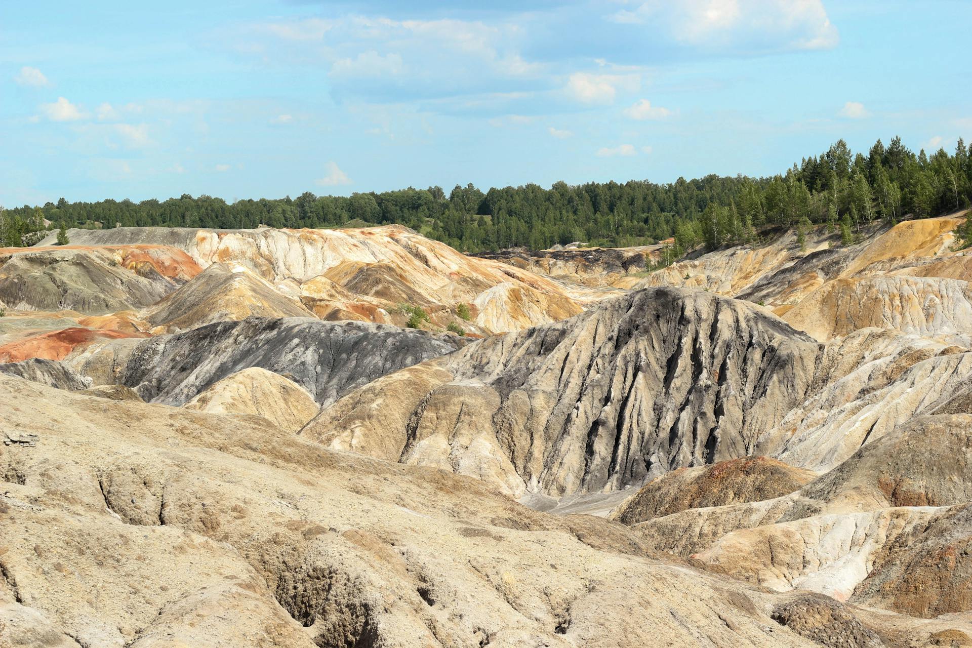 Vivid geological formations at open pit mines in Sverdlovsk, Russia showcase diverse soil layers.