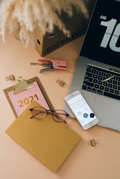 Well-organized office desk featuring a clipboard marked 2021, laptop, and smartphone.