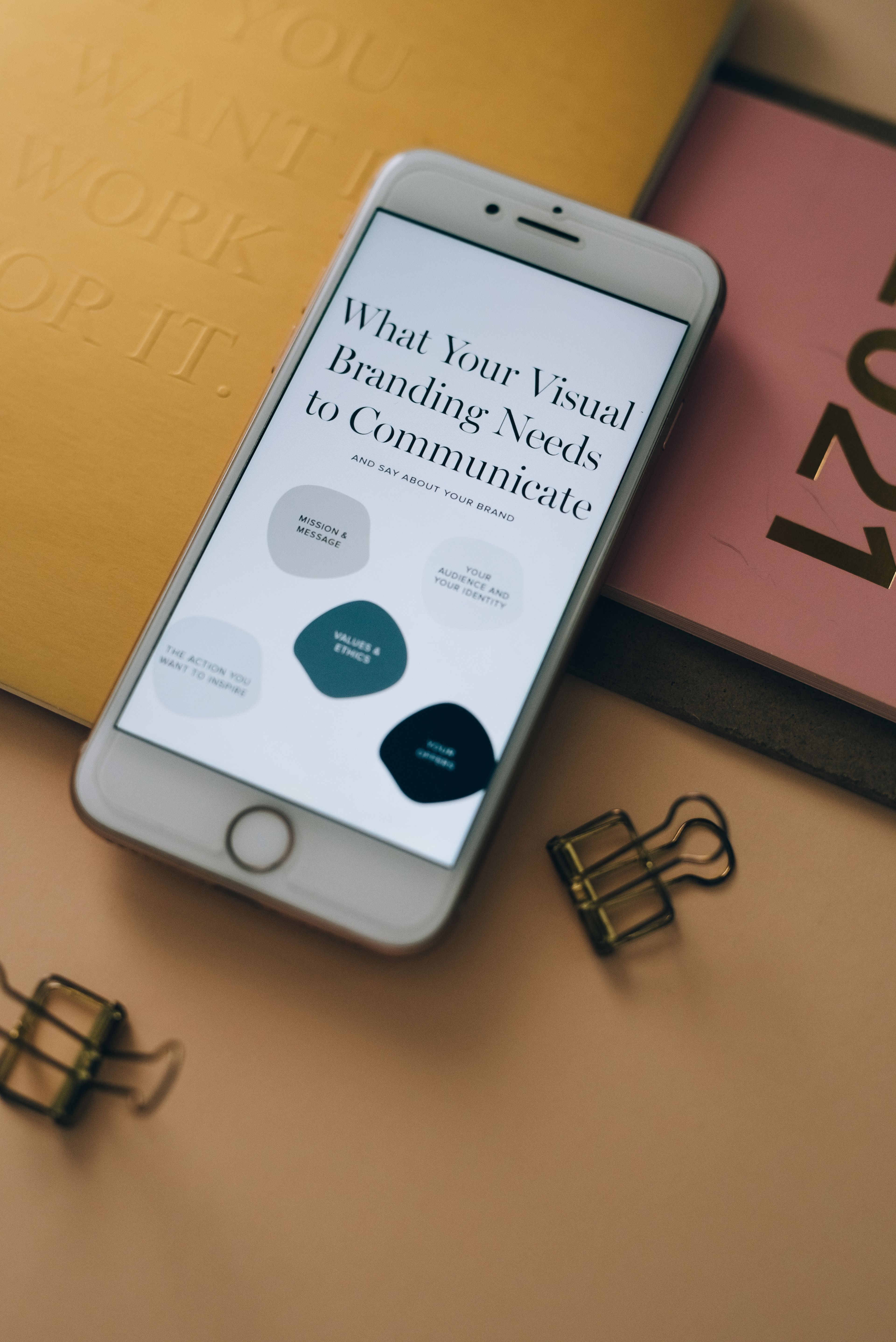 The Lumen brand guide on a phone beside the stationery
