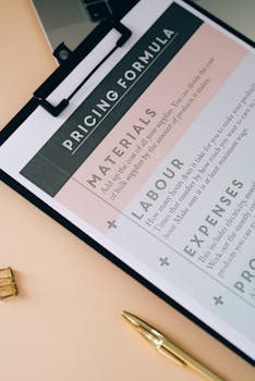 Photo by Leeloo The First Close-up of a clipboard showcasing a pricing formula with a pen on the desk.