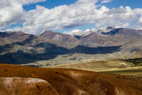 Free Breathtaking view of the Altai Mountains with clouds casting shadows in Russia. Stock Photo
