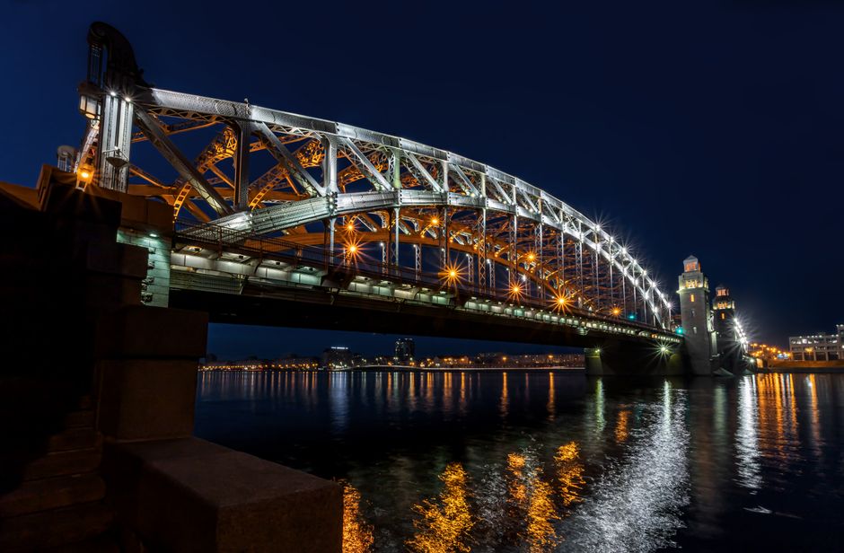 Puente Bolsheokhtinsky por la noche con reflejos en el río Neva, San Petersburgo