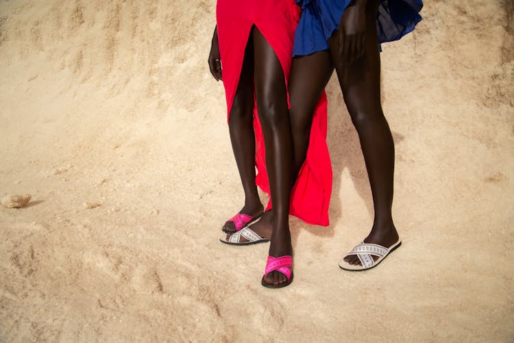 Women Wearing Slippers Standing On Sand