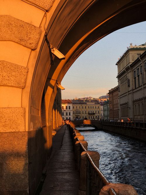 Free Warm sunset light casts shadows over an archway and canal in St. Petersburg, Russia. Stock Photo