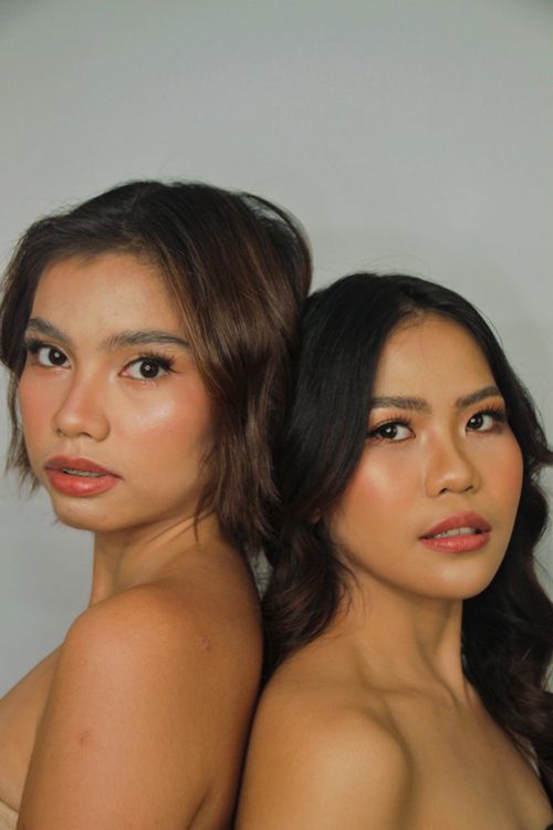 Free Close-up portrait of two women showcasing natural beauty and elegance in a studio setting. Stock Photo