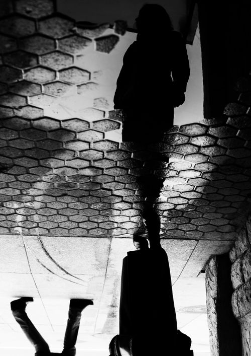 Free A black and white street photo capturing reflections on a wet sidewalk in Saint Petersburg. Stock Photo