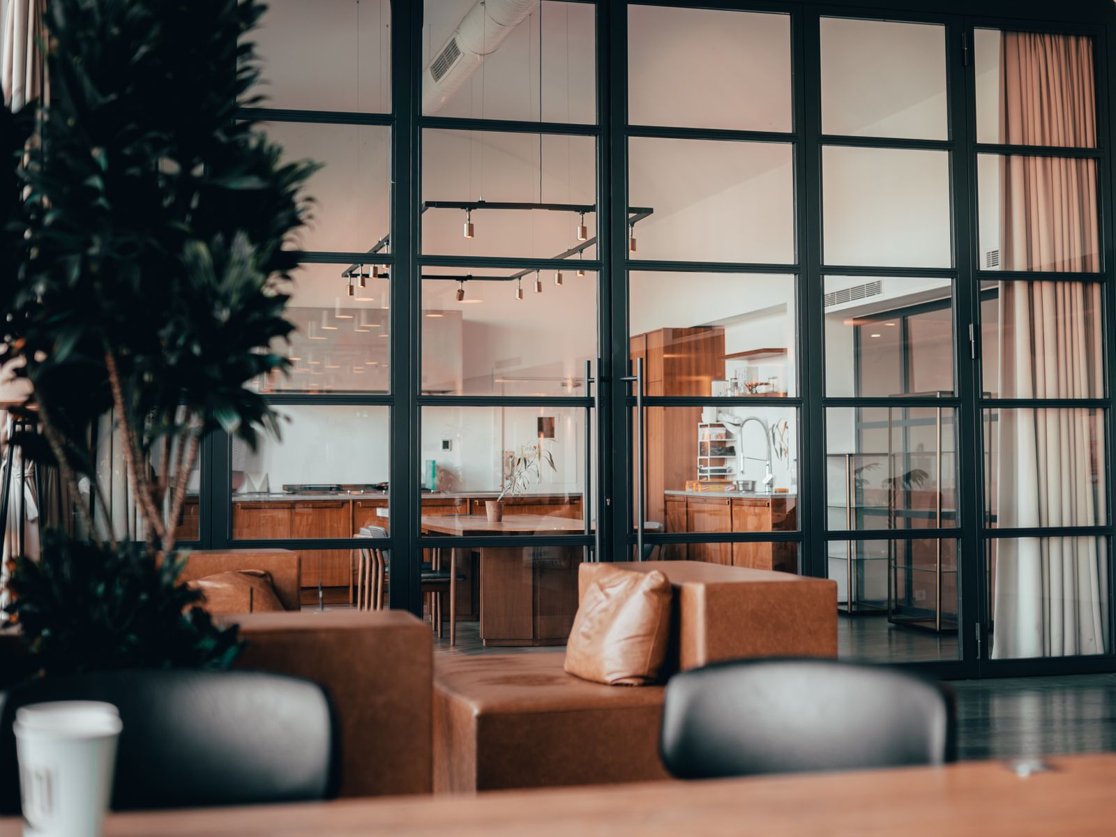 Aluminium framed glass room partition dividing a dark interior