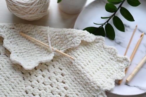 White Knit Textile and Wooden Sticks