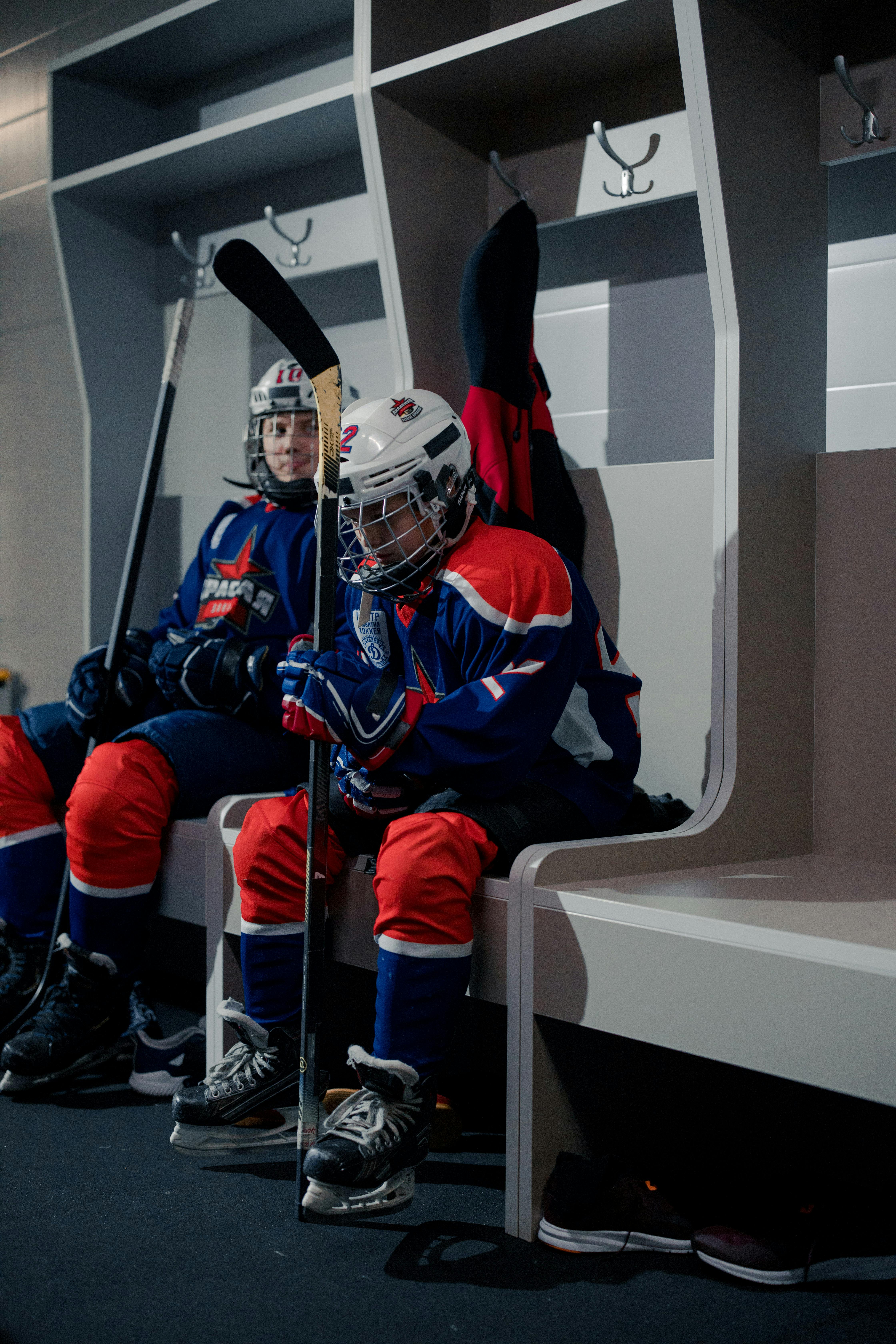 man in blue and red suit wearing helmet sitting on white chair