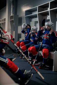 Young ice hockey players in a locker room gearing up before a game, showing team spirit and focus.