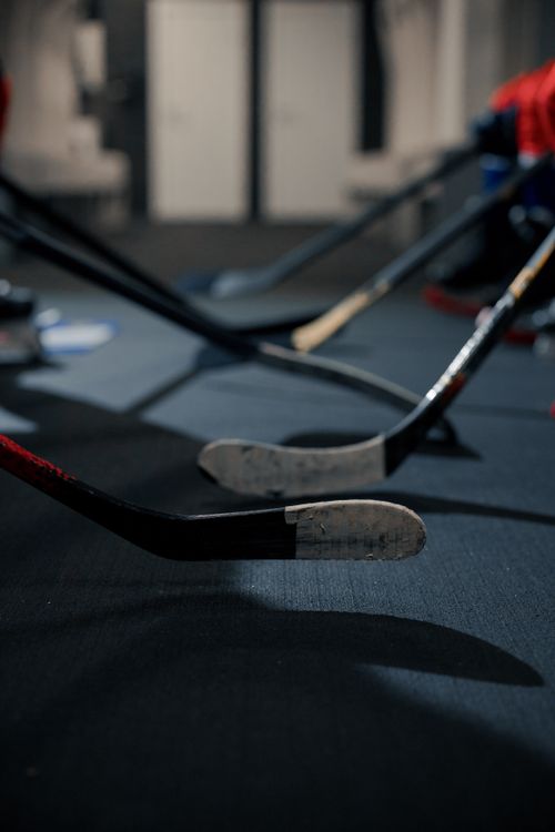 Free Close-up of hockey sticks on the floor of a dressing room, ready for a game. Stock Photo