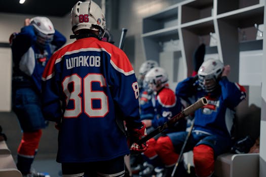 Young ice hockey players in a locker room getting ready, showcasing team spirit and preparation.