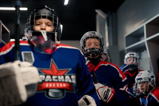 Youth hockey players in full gear, ready for a game in the locker room.