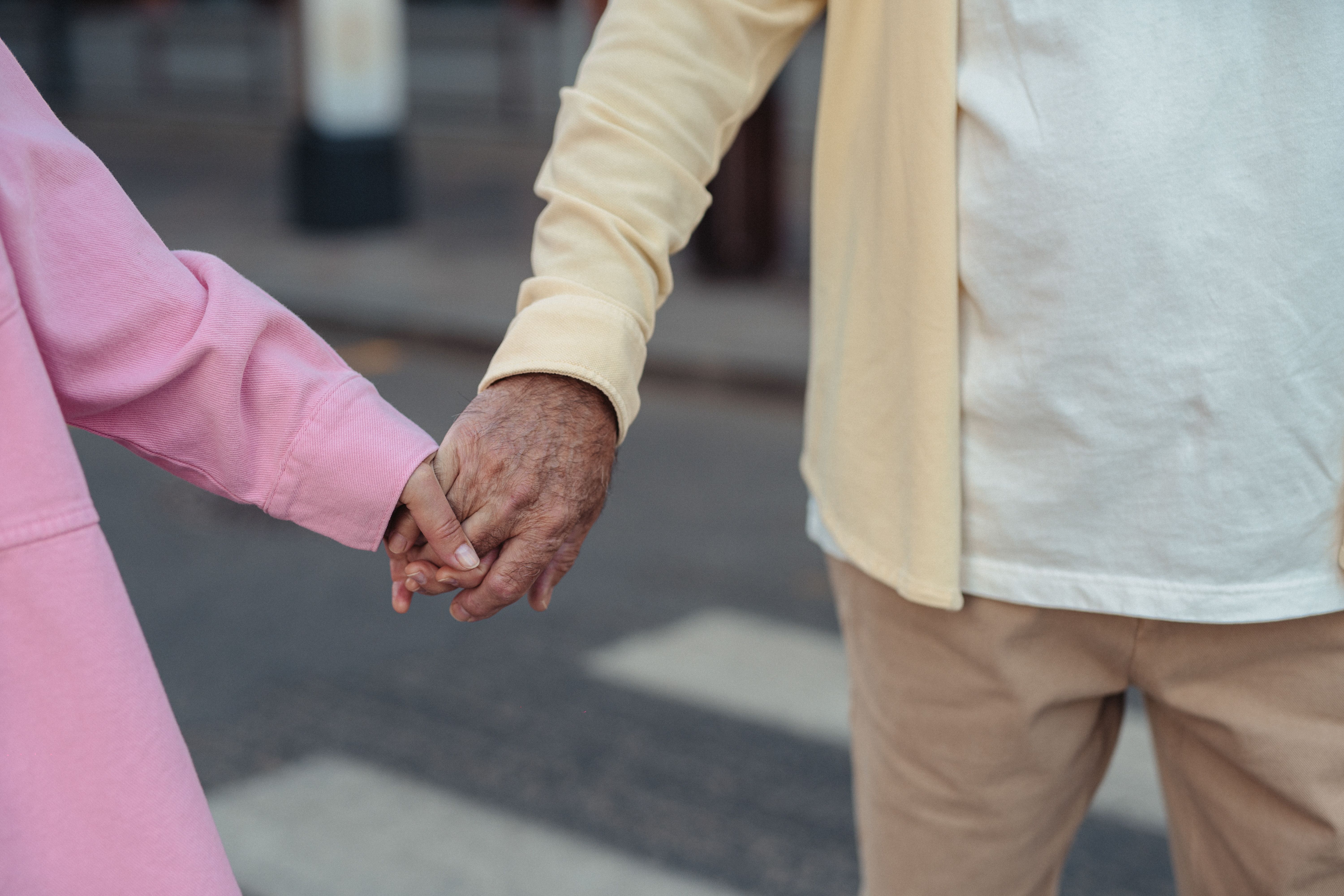 Close-up of an elderly couple holding hands, symbolizing love and companionship.