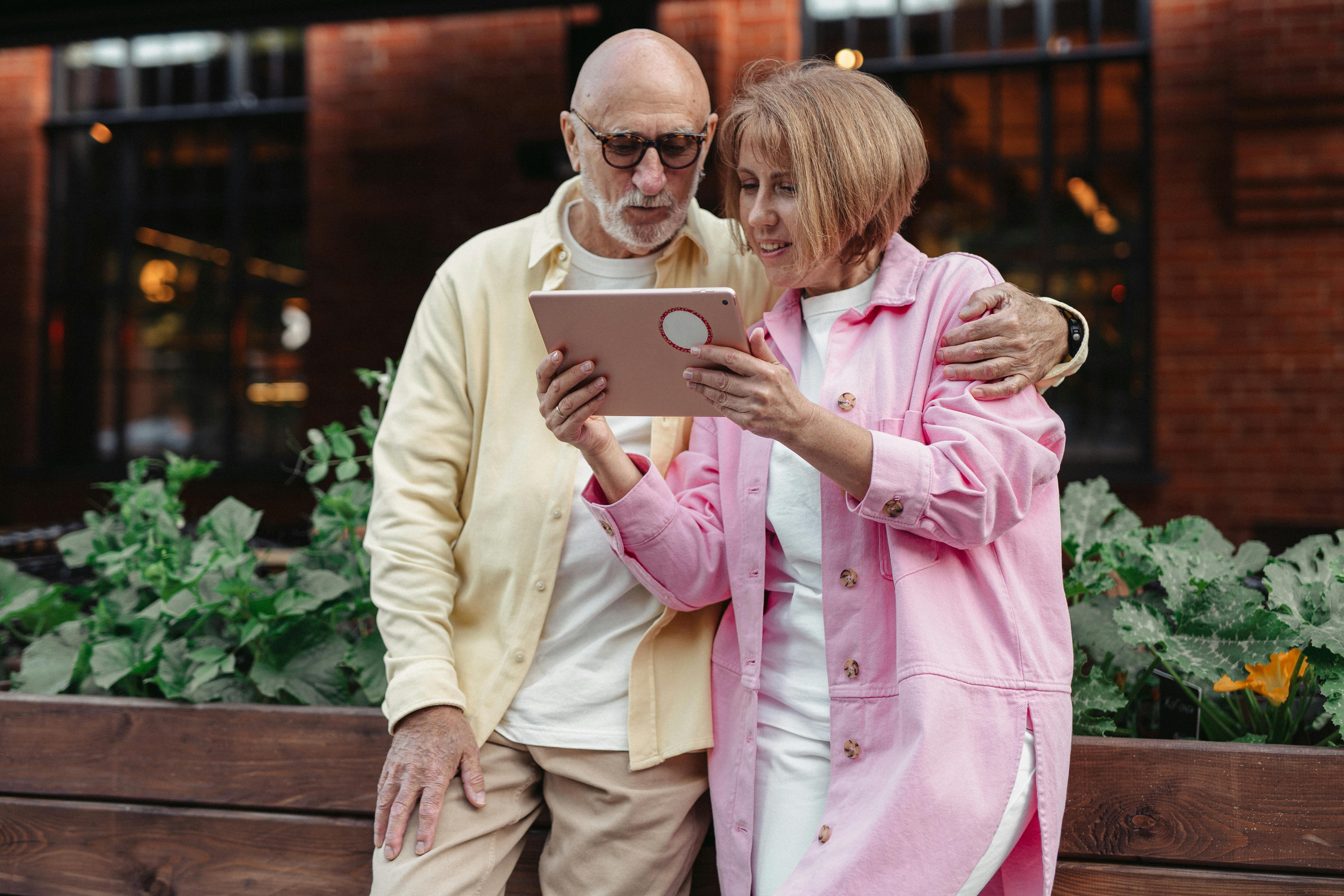 man in pink dress shirt holding ipad