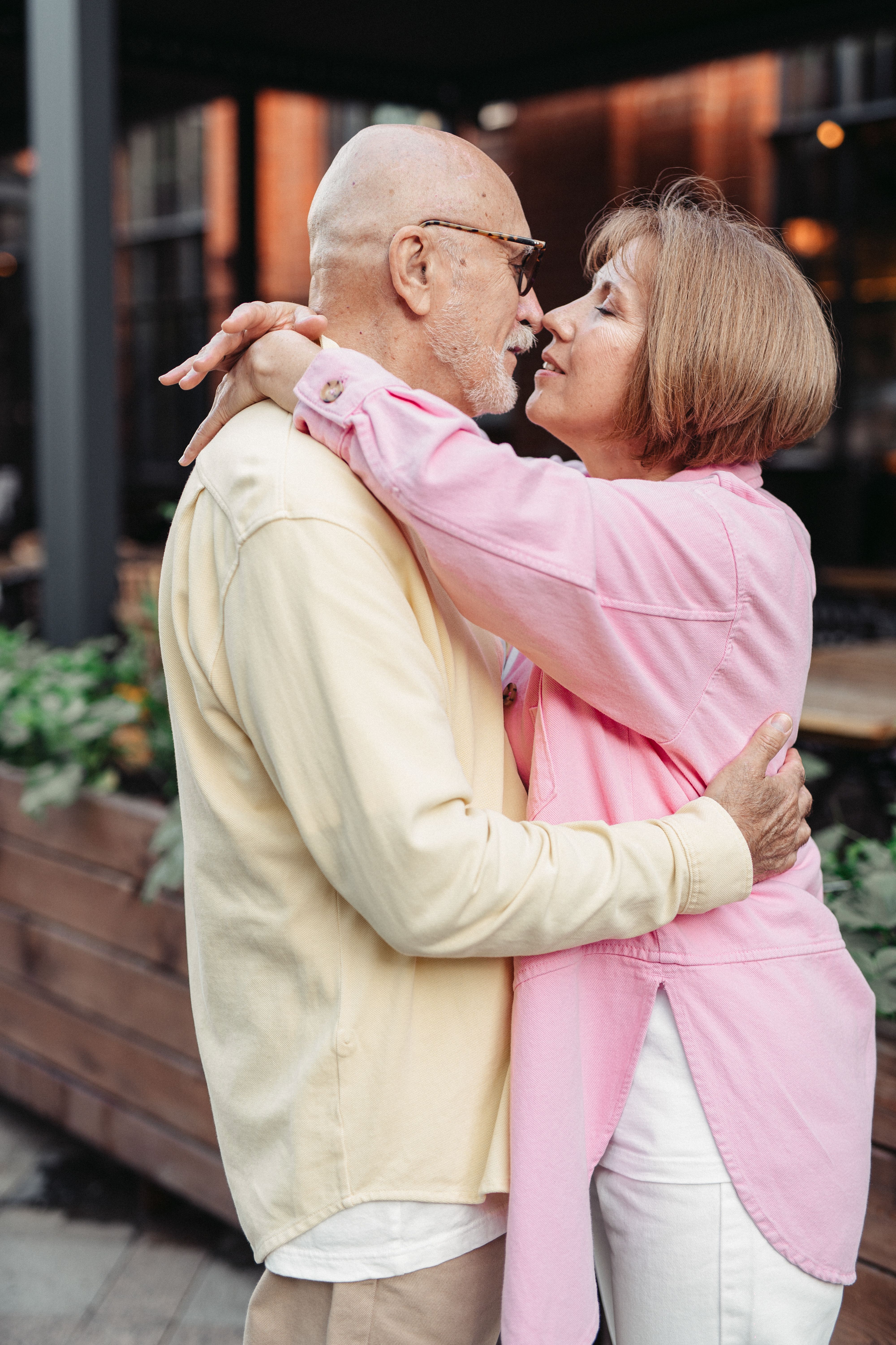 Senior couple sharing an intimate hug and kiss outdoors. A moment of romance and affection.