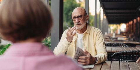 Elderly couple conversing at an outdoor cafe, enjoying a peaceful moment together.